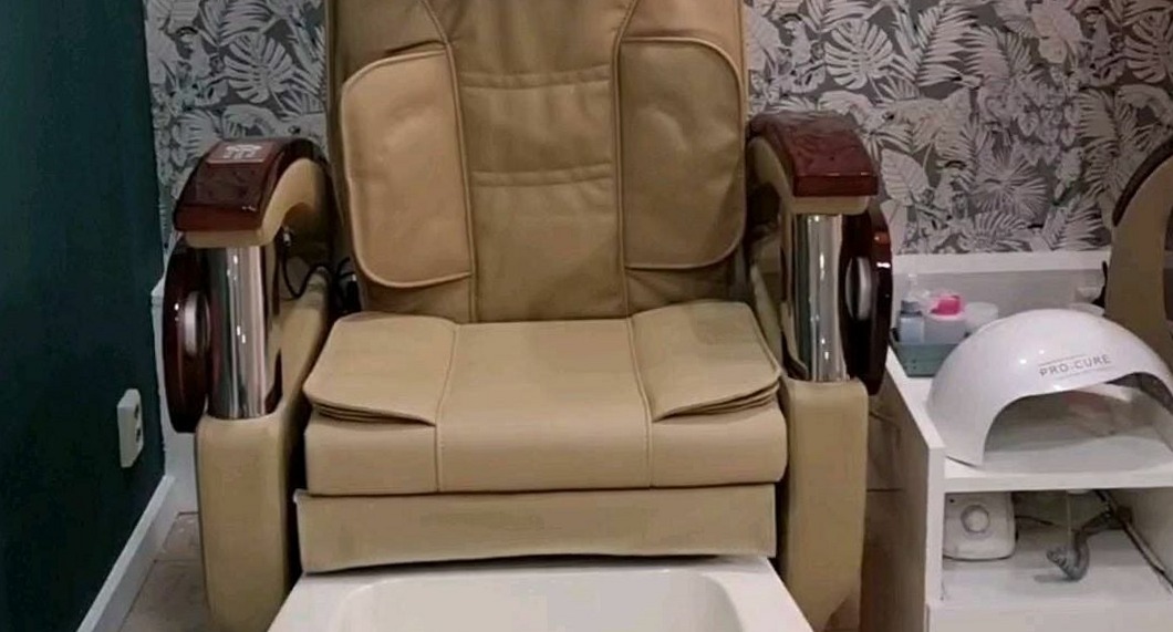 Pedicurestoel met nagellamp voor het bladerbehang in de salon