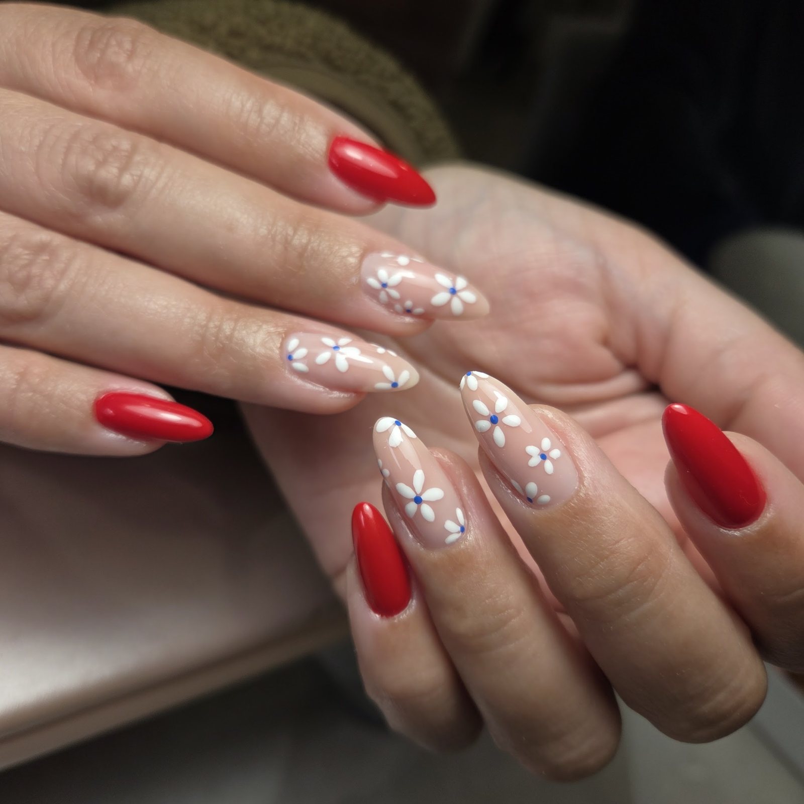 Rode amandelnagels en nude nagels met witte bloemetjes