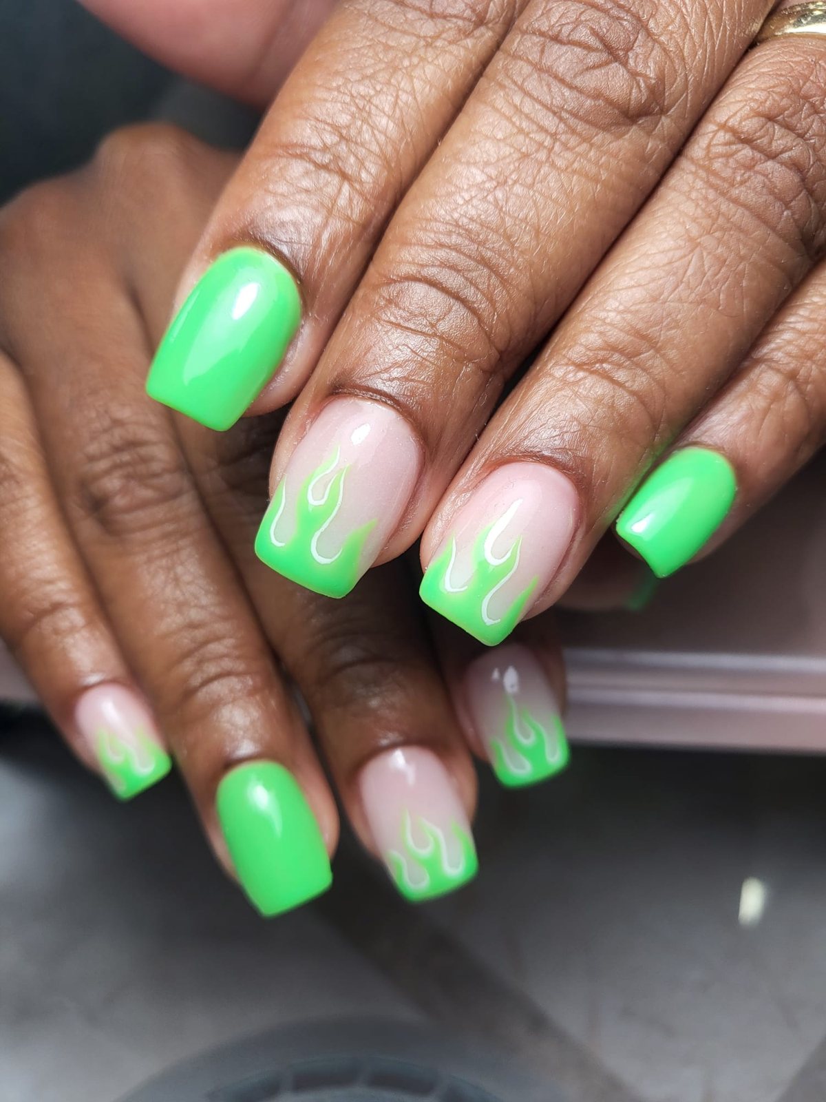 Neongroene nagels en roze nagels met groene vlammen