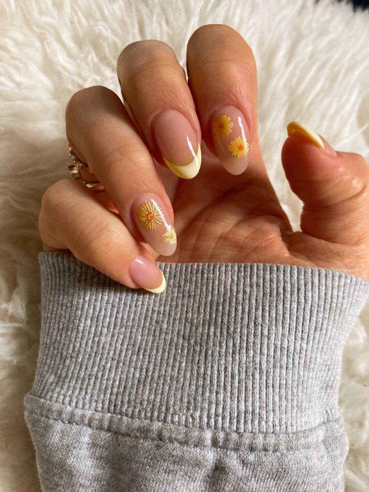French nagels met gele details tegen een witte vacht